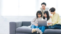 微笑的姊妹和家人看著筆記型電腦