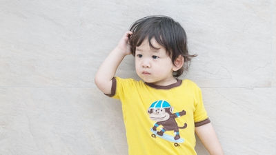 小男孩摸頭困惑