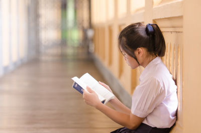 女生坐在地上看書